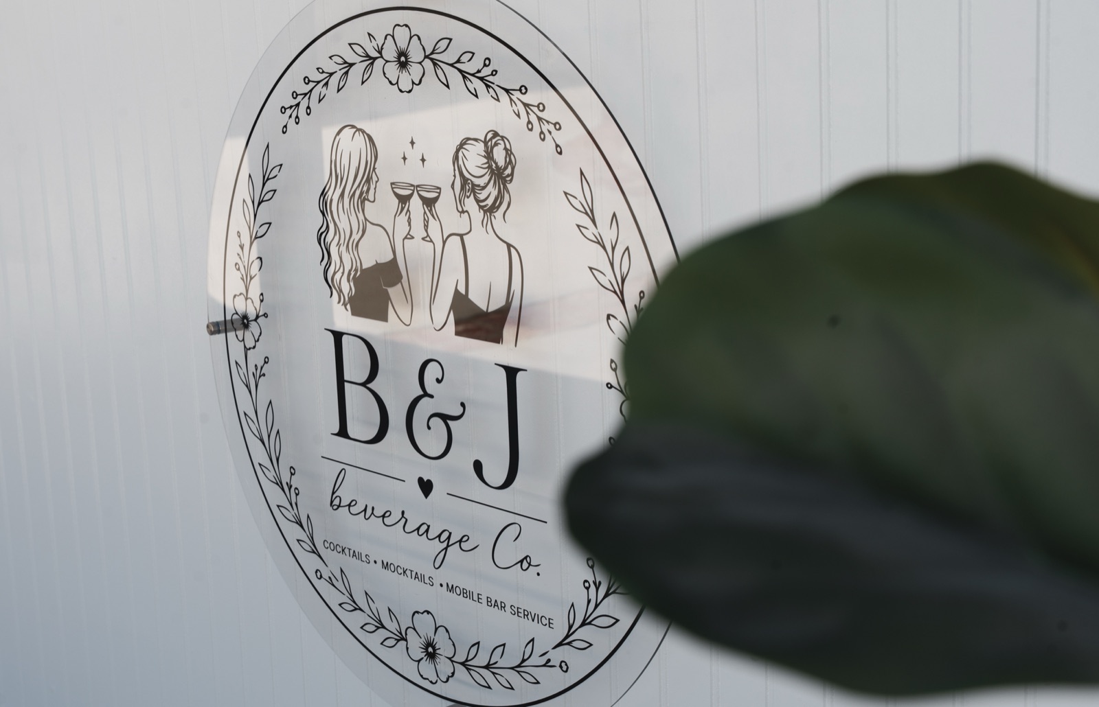 The B&J Beverage Co. acrylic sign on the white bar front